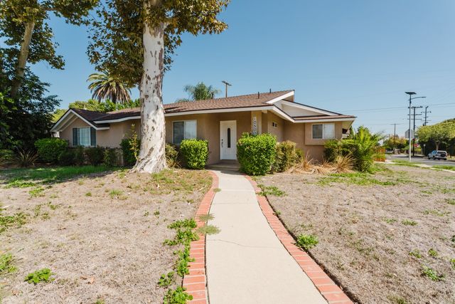Front exterior of 10500 Dempsey Avenue, a single-story house on a corner lot with a brick-edged walkway and mature trees