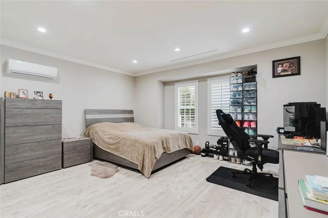 Bedroom with light flooring, recessed lighting and white window shutters